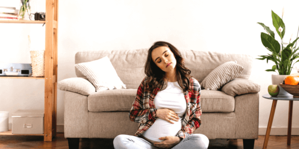 Contemplative woman post-IVF with donor egg, touching belly